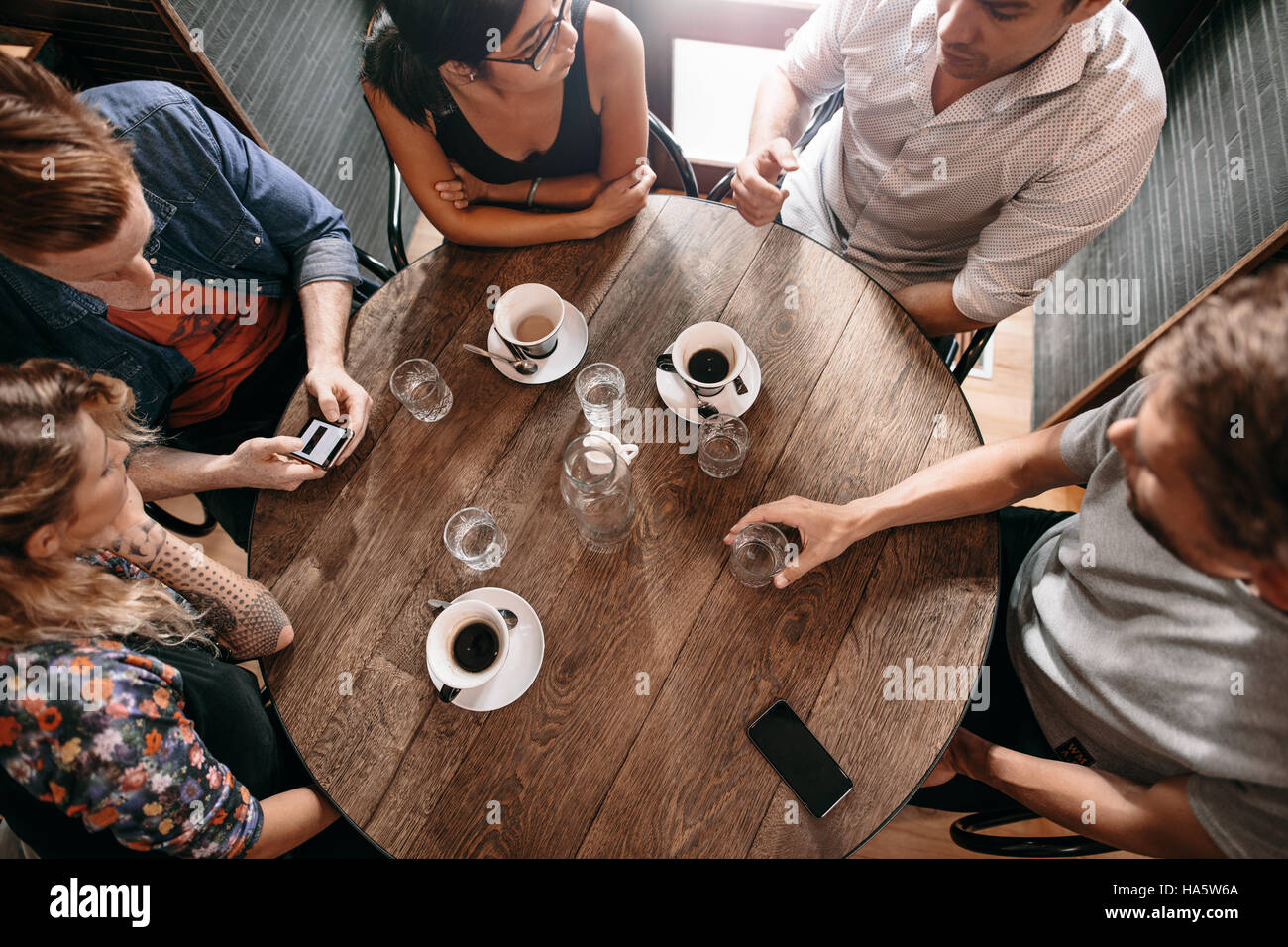 Draufsicht der Jugendlichen im Café mit Kaffee am Tisch sitzen. Gruppe von Freunden im Café. Stockfoto