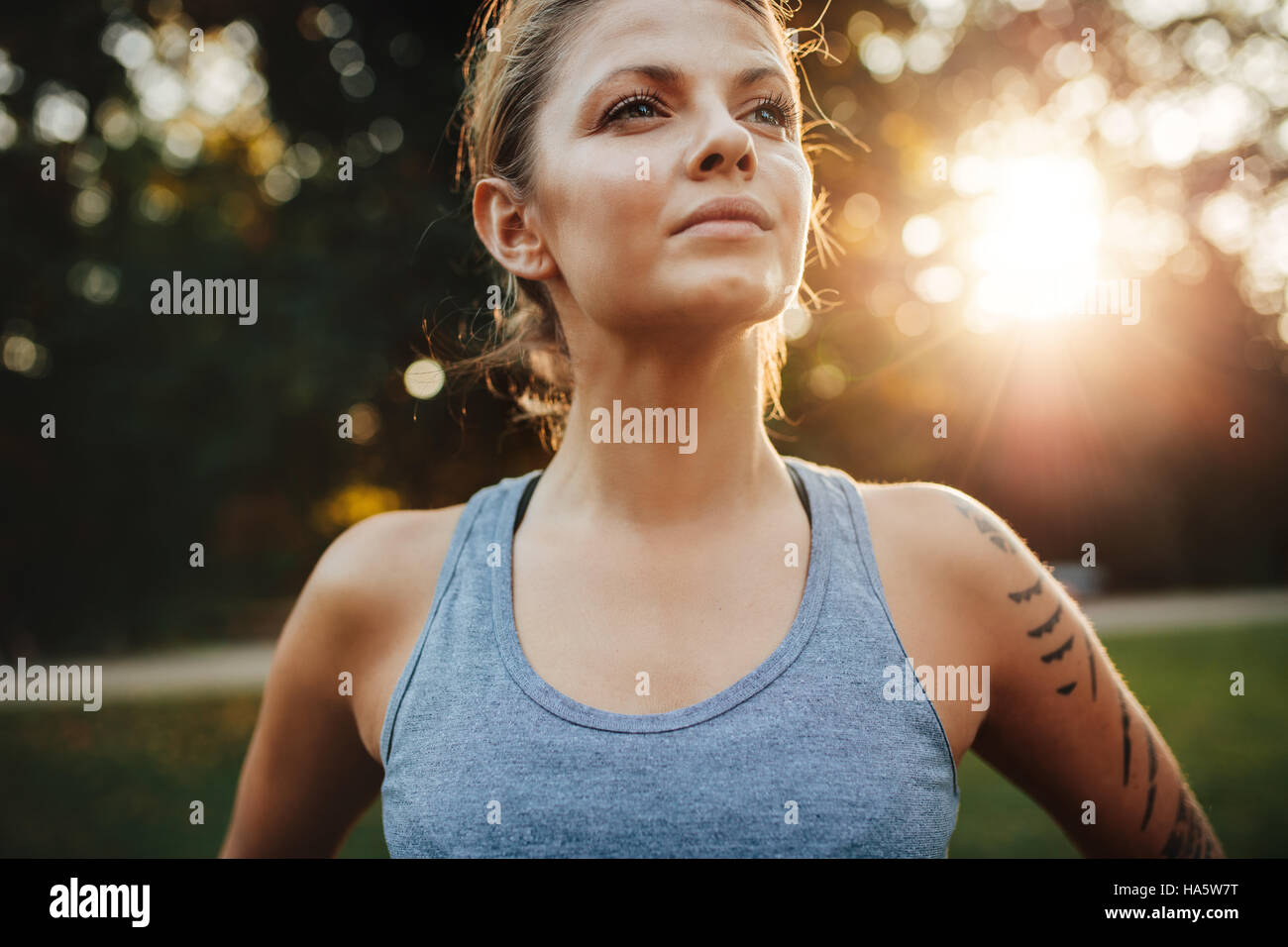 Porträt von Fit junge Frau in Sportkleidung im Freien stehen und wegsehen hautnah. Zuversichtlich Fitness-Modell im Park. Stockfoto