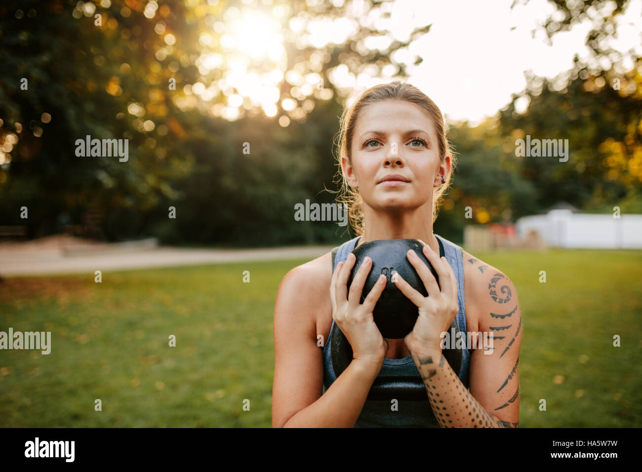 Porträt von Fit junge Frau dabei Training mit Kettlebell. Fit und muskulöse Frau Gymnastik im Park. Stockfoto