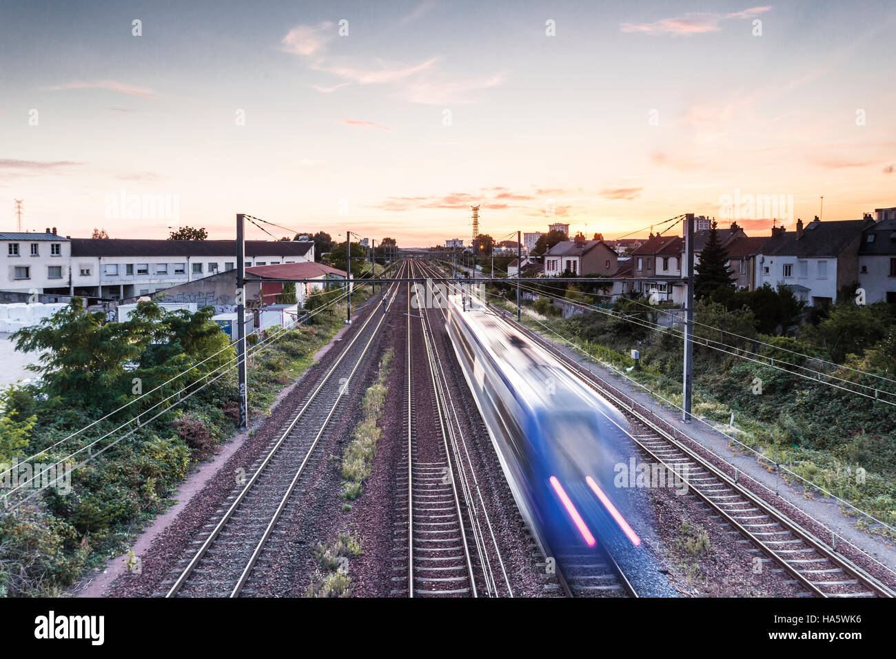 Ein französischer Zug beschleunigt aus in den Sonnenuntergang. Stockfoto