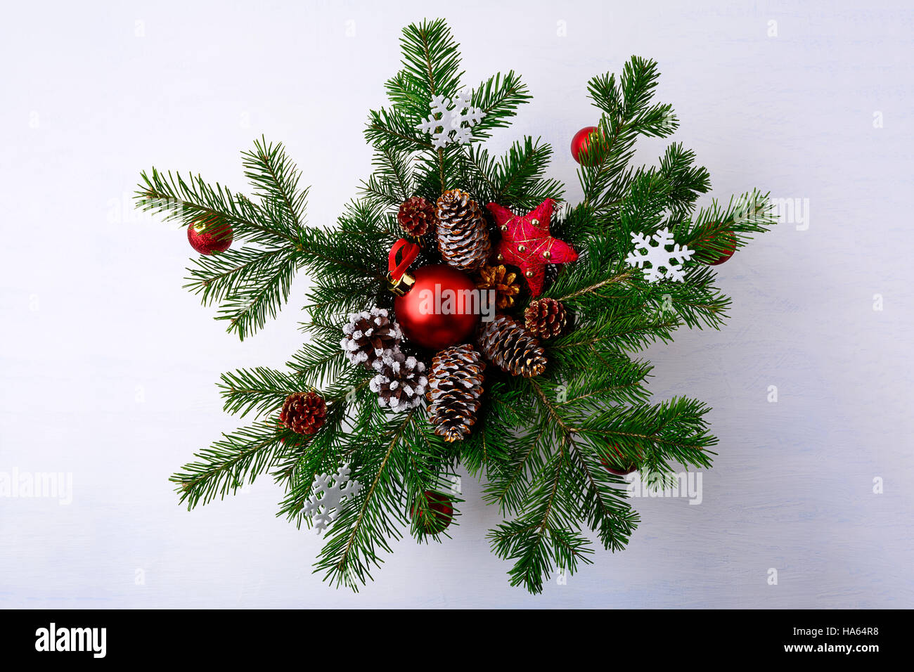 Rote Weihnachtskugeln und verschneiten dekorierte Pinienzapfen Kranz. Weihnachten Hintergrund mit Tannenzweigen. Stockfoto