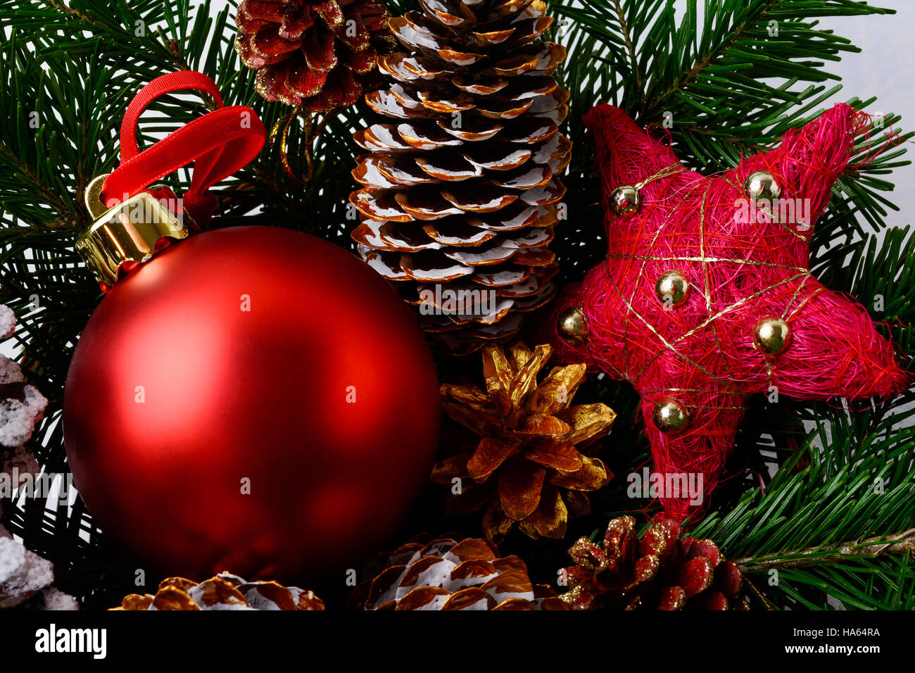 Rote Weihnachtskugeln und verschneiten dekorierte Pinienzapfen. Weihnachten Hintergrund mit Tannenzweigen. Stockfoto