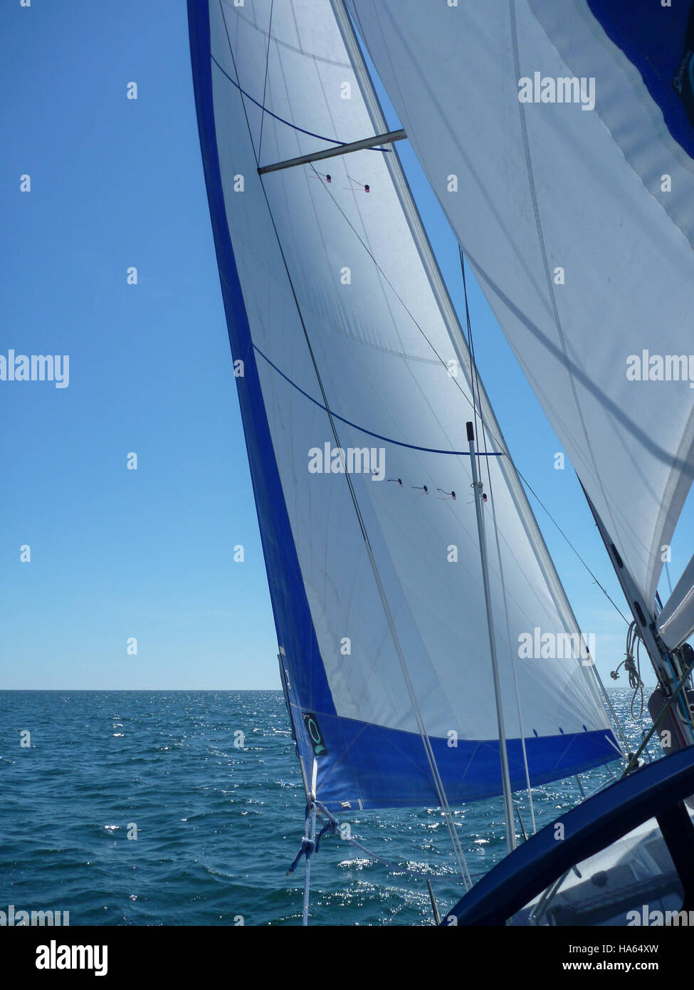 Ein yacht Fock und Großsegel gegen ein blaues Meer, blauer wolkenloser Himmel mit Kontrollleuchten perfekt fliegen. Stockfoto