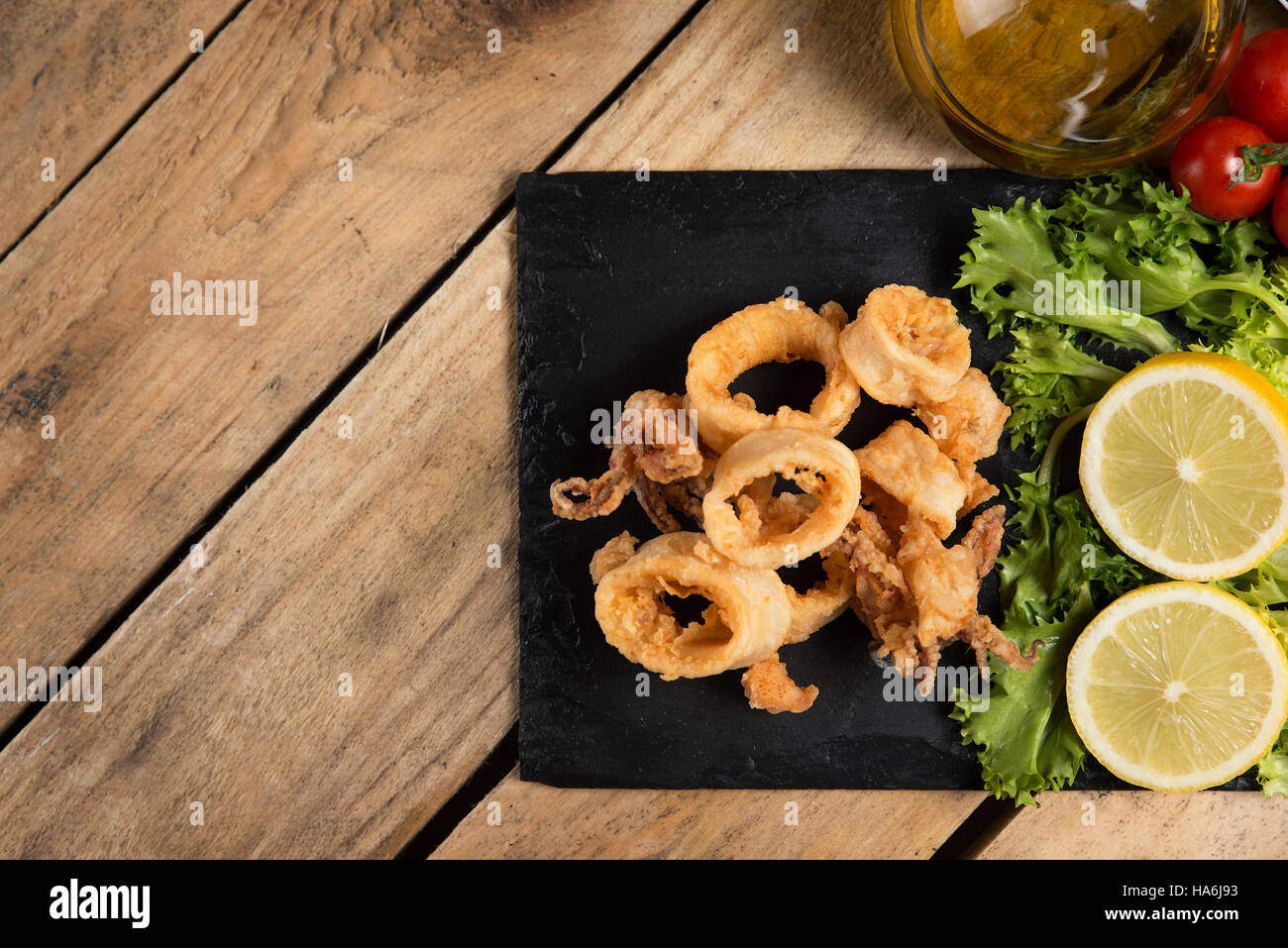 knusprig gebratenen Calamari auf Schiefer Teller serviert Stockfoto