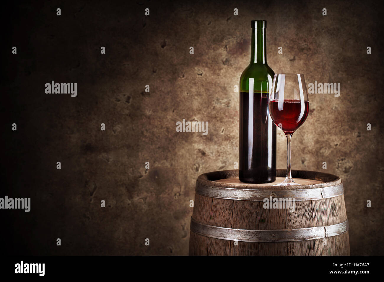 Flasche und Glas Rotwein im Holzfass mit dunklem Hintergrund gedreht Stockfoto