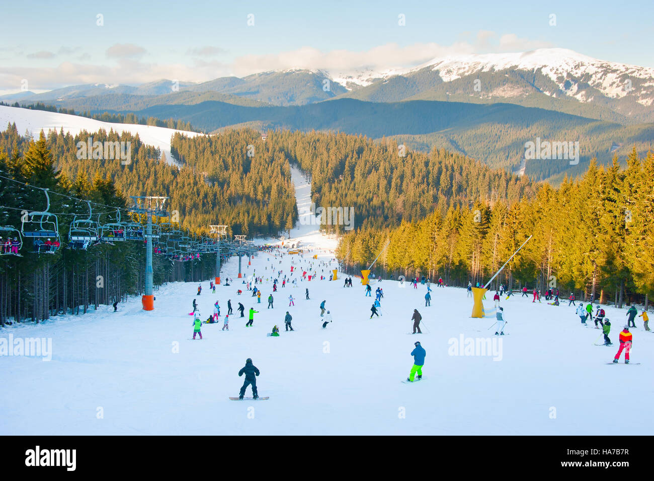 Menschen, Skifahren und Snowboarden auf der Piste Stockfoto