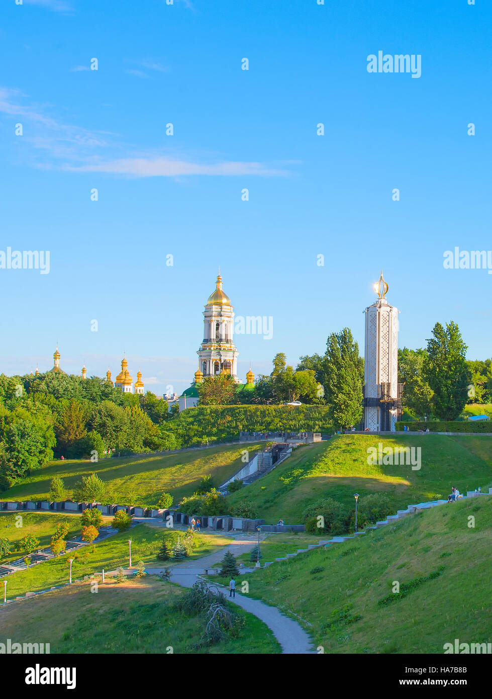 Park der Ruhm mit Denkmälern des Holodomor. Kuppel des Kiewer Höhlenkloster Lawra auf dem Hintergrund Stockfoto