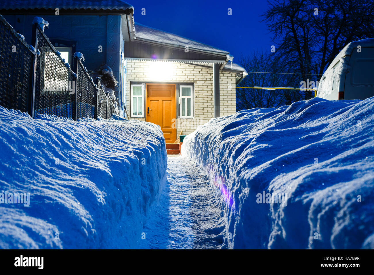 Schmale Spur in riesigen Schneewehe zu einem Haus in Landschaft gegraben Stockfoto