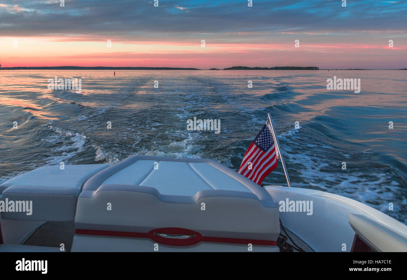 Motorboot mit amerikanischen Flagge und Sonnenuntergang unterwegs Stockfoto