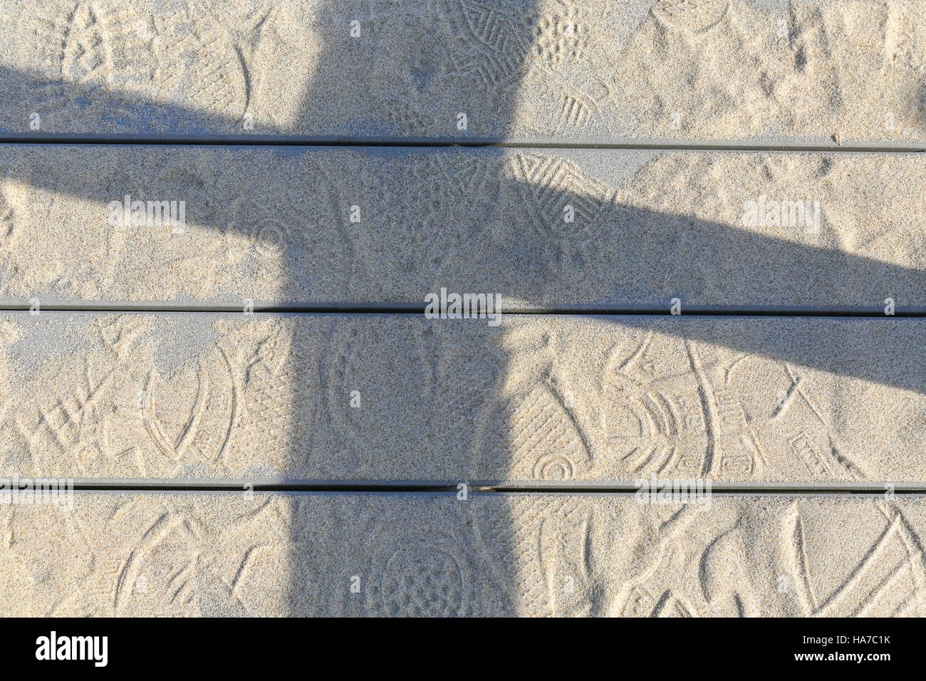 Detail einer ein Deck mit Sand, Fuß druckt und Schatten Stockfoto