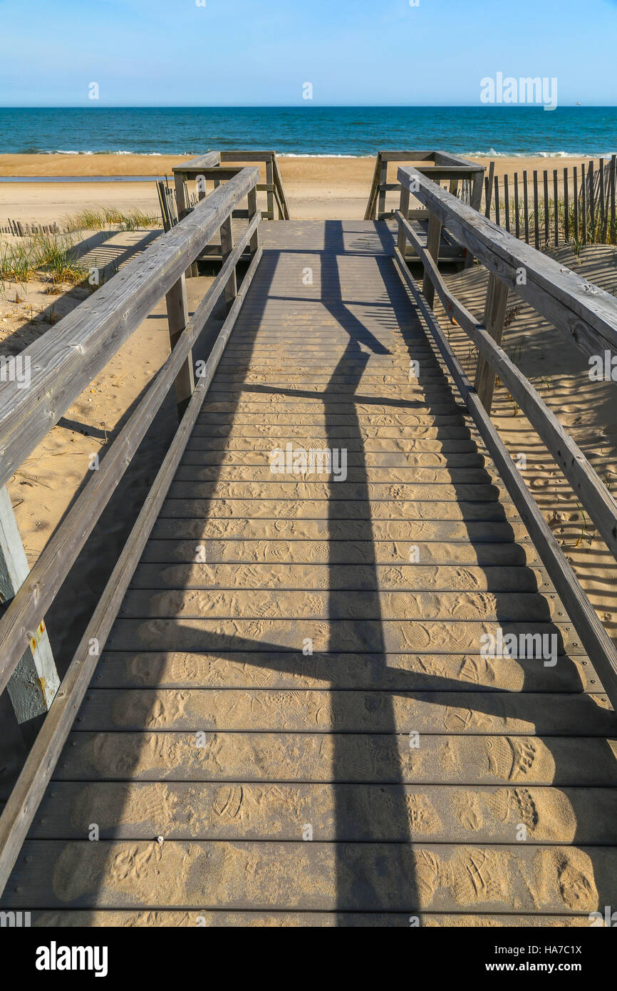 Brett zu Fuß zum Strand mit Schatten, Sand und Meer im Hintergrund Stockfoto
