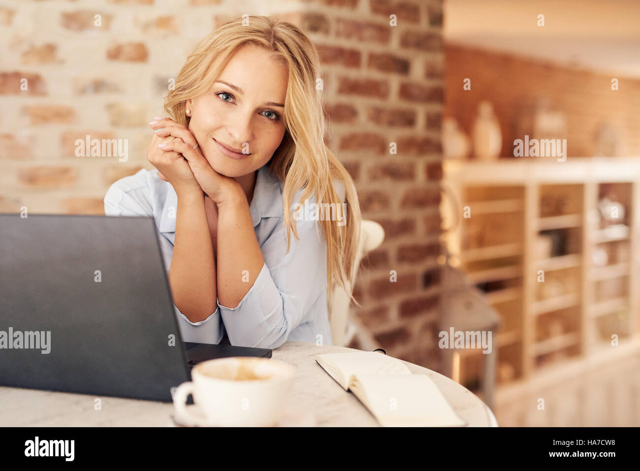 Attraktive junge Frau mit einem Laptop zu Hause Stockfoto