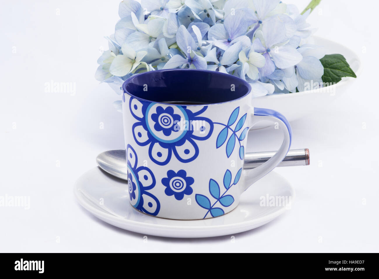 Kaffee-Haferl und Hortensie auf weißem Hintergrund Stockfoto