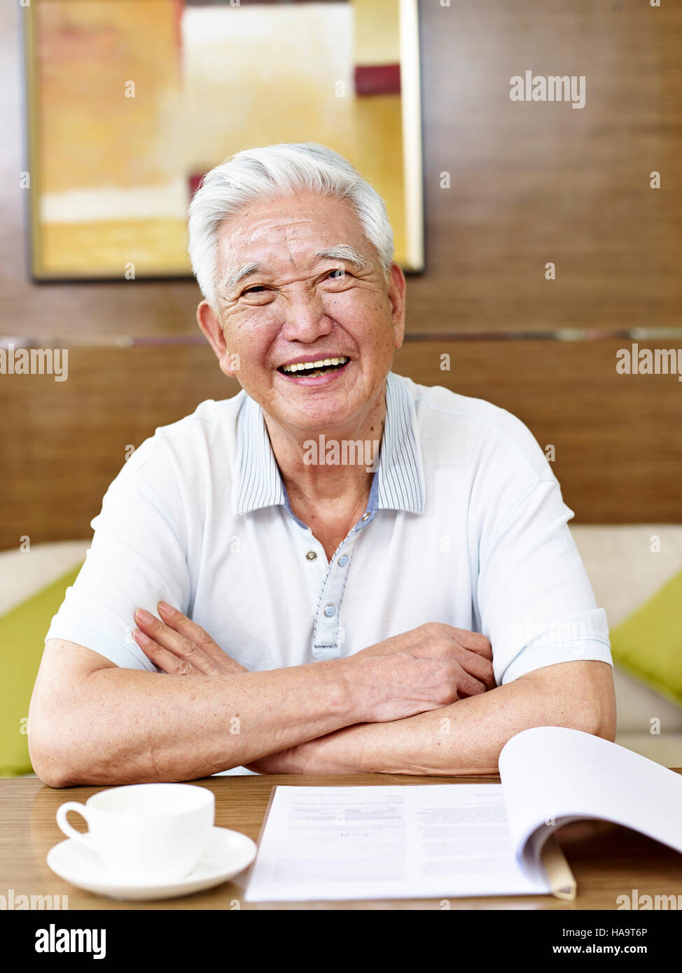 Senior asiatischen Mann liest ein Buch oder ein Dokument im Arbeitszimmer Stockfoto
