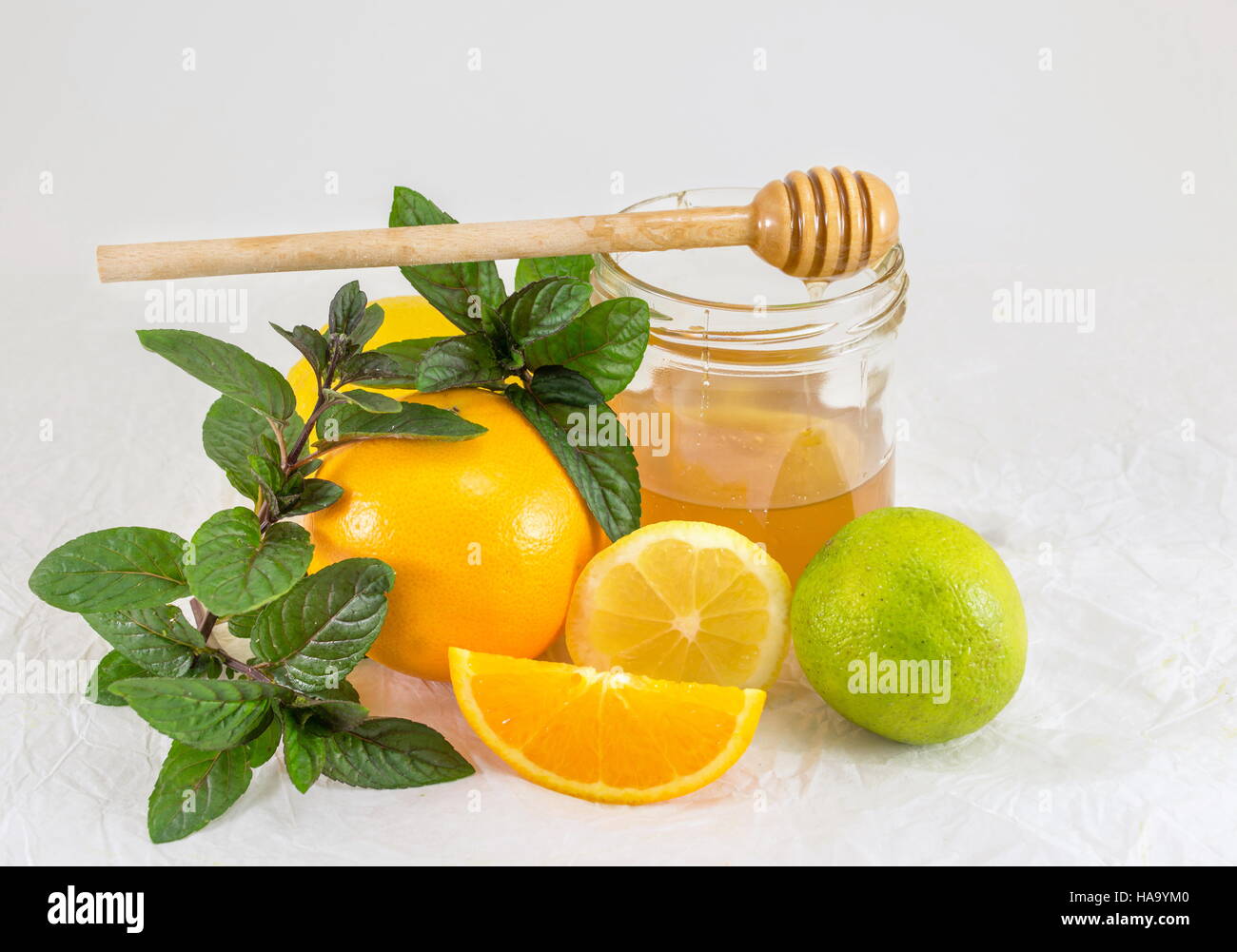 Jer Honig mit Zitrone, Limette und Kräutern auf weiß Stockfoto