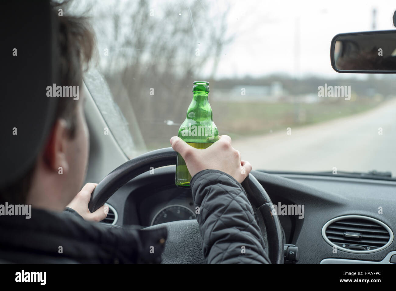 Junger Mann mit seinem Auto beim trinken Alkohol Stockfoto