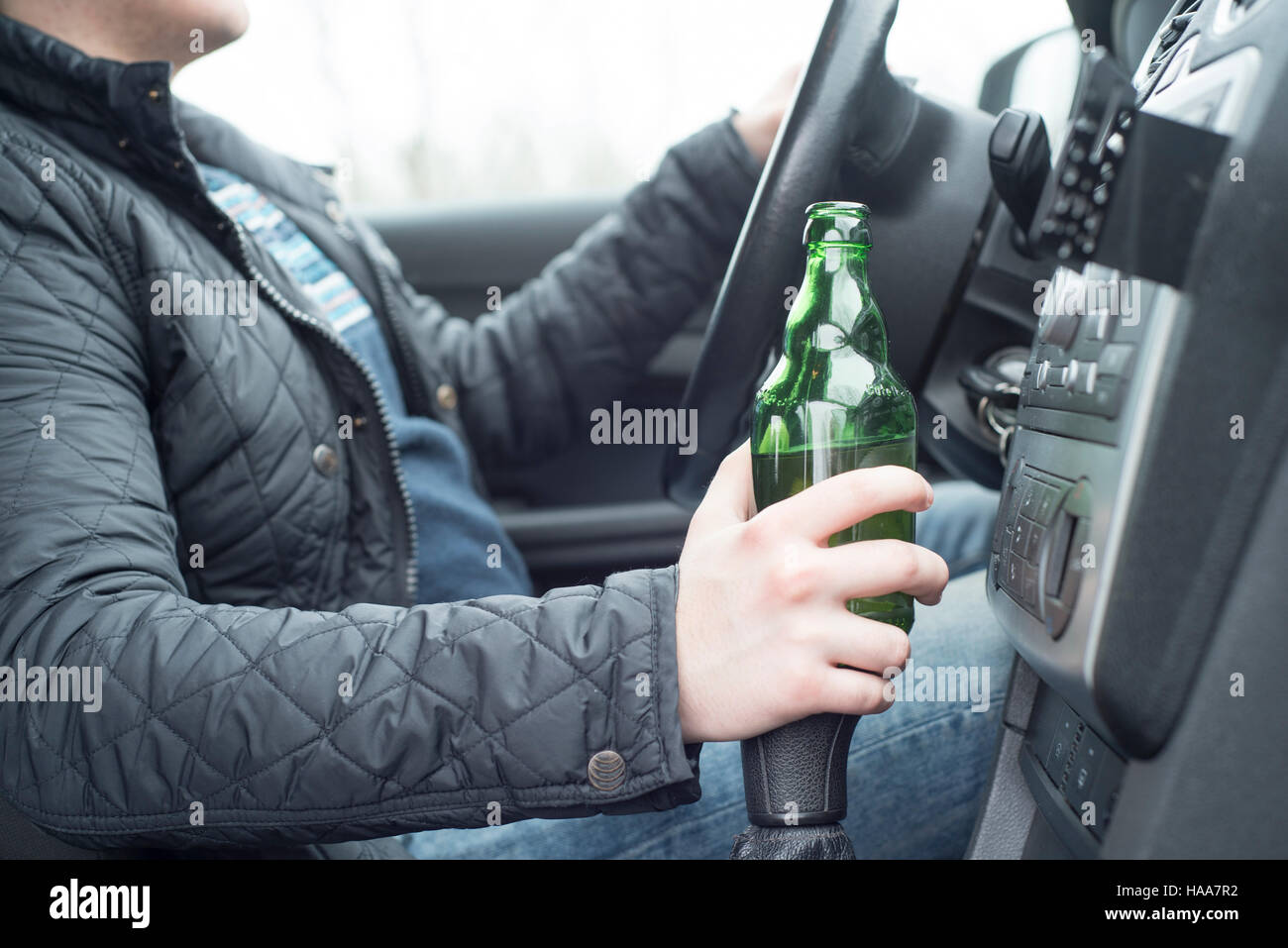 Junger Mann mit seinem Auto beim trinken Alkohol Stockfoto
