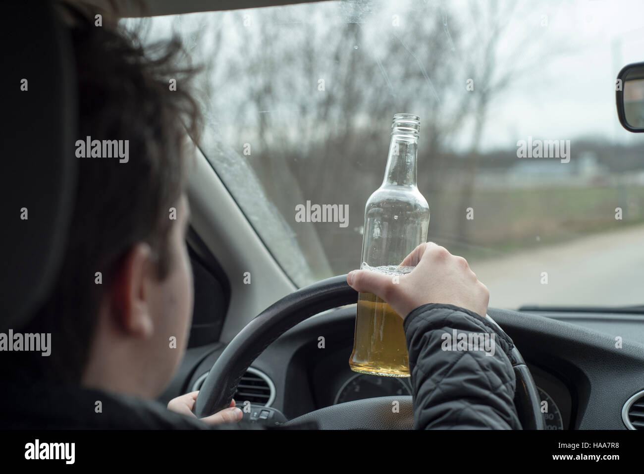 Junger Mann mit seinem Auto beim trinken Alkohol Stockfoto