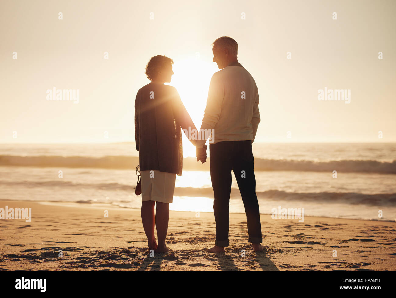 Silhouette Of A Couple Holding Hands On Beach At Sunset Fotos Und Bildmaterial In Hoher 