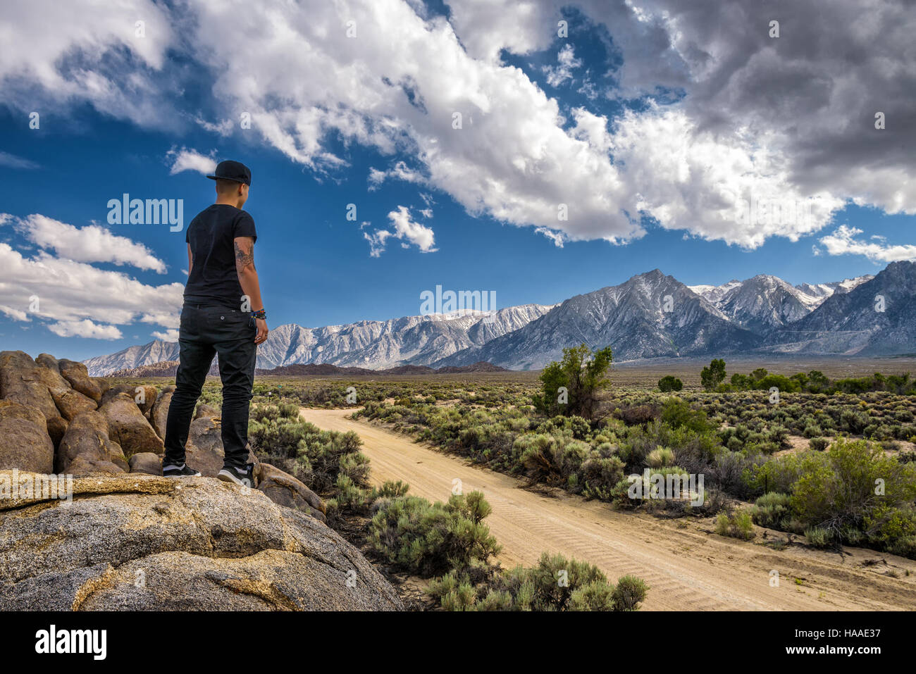 Junge Person, die über eine unbefestigte Straße in Alabama Hills in die Berge der Sierra Nevada in der Nähe von Lone Pine, Kalifornien, USA Stockfoto