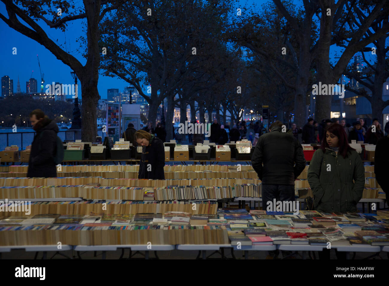 Menschen auf der Suche nach Bücher an den Sekundenzeiger Buch Ständen unter Waterloo Bridge auf der Southbank, London, Vereinigtes Königreich. South Bank ist eine bedeutende Kunst- und Vergnügungsviertel und Heimat für eine endlose Liste von Aktivitäten für Londoner, Besucher und Touristen gleichermaßen. Stockfoto