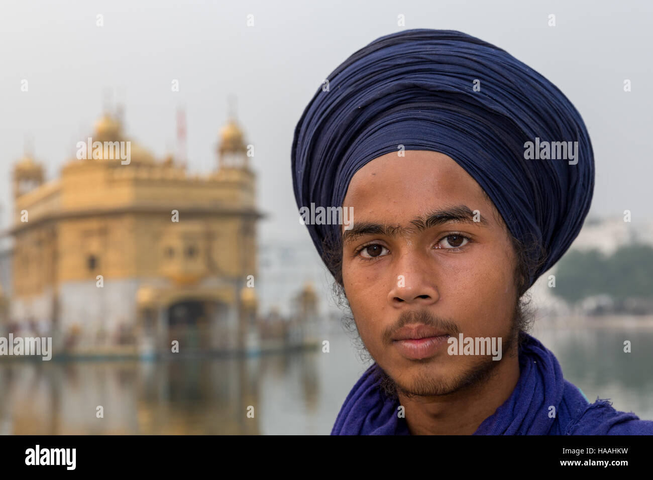 Ein Junge Sikh-Pilger vor The Golden Temple Complex in der Sikh Stadt Amritsar, Punjab, Nordindien Stockfoto