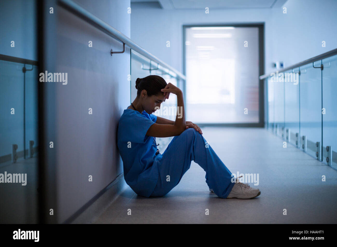 Traurig Krankenschwester im Flur sitzen Stockfoto