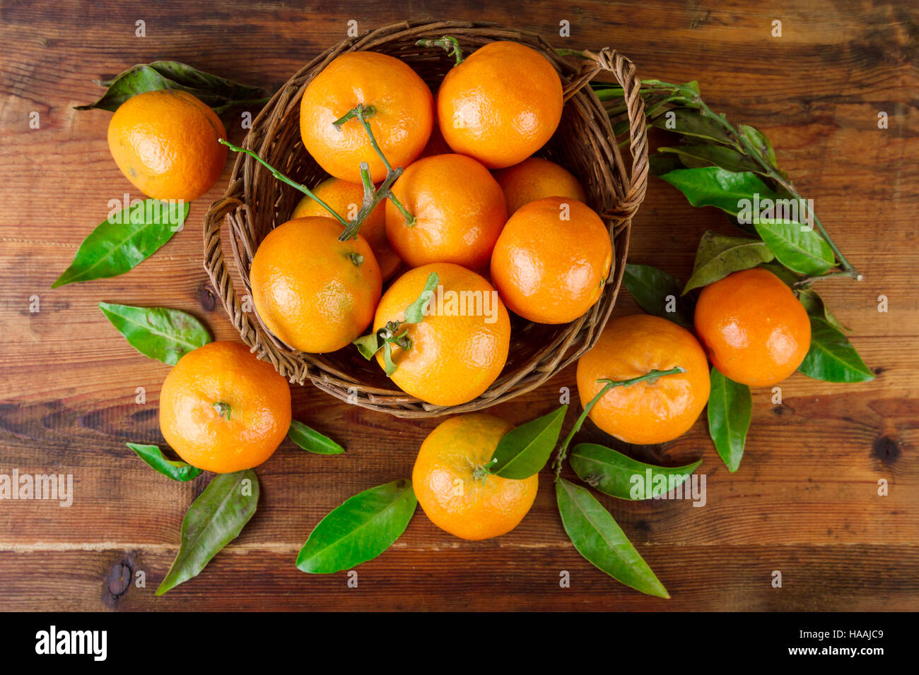 Mandarinen-Korb über alten Holztisch Draufsicht Stockfoto