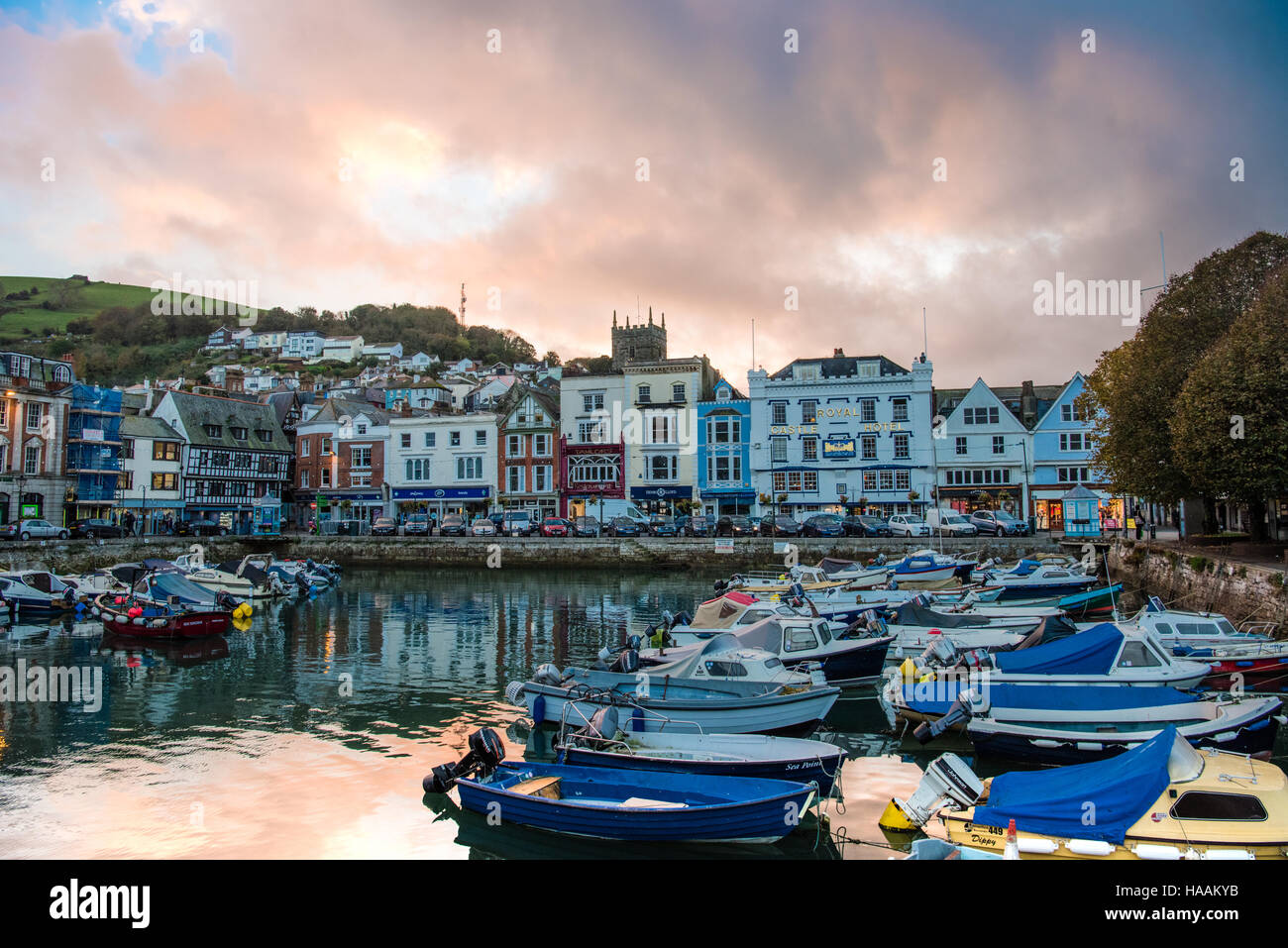 Historischen Boot Schwimmer in der ziemlich gehobenen Devon Rivertown Dartmouth wie die Sonne geht hinter bunten Altbauten, die Kirche und berühmten Royal Hotel Stockfoto