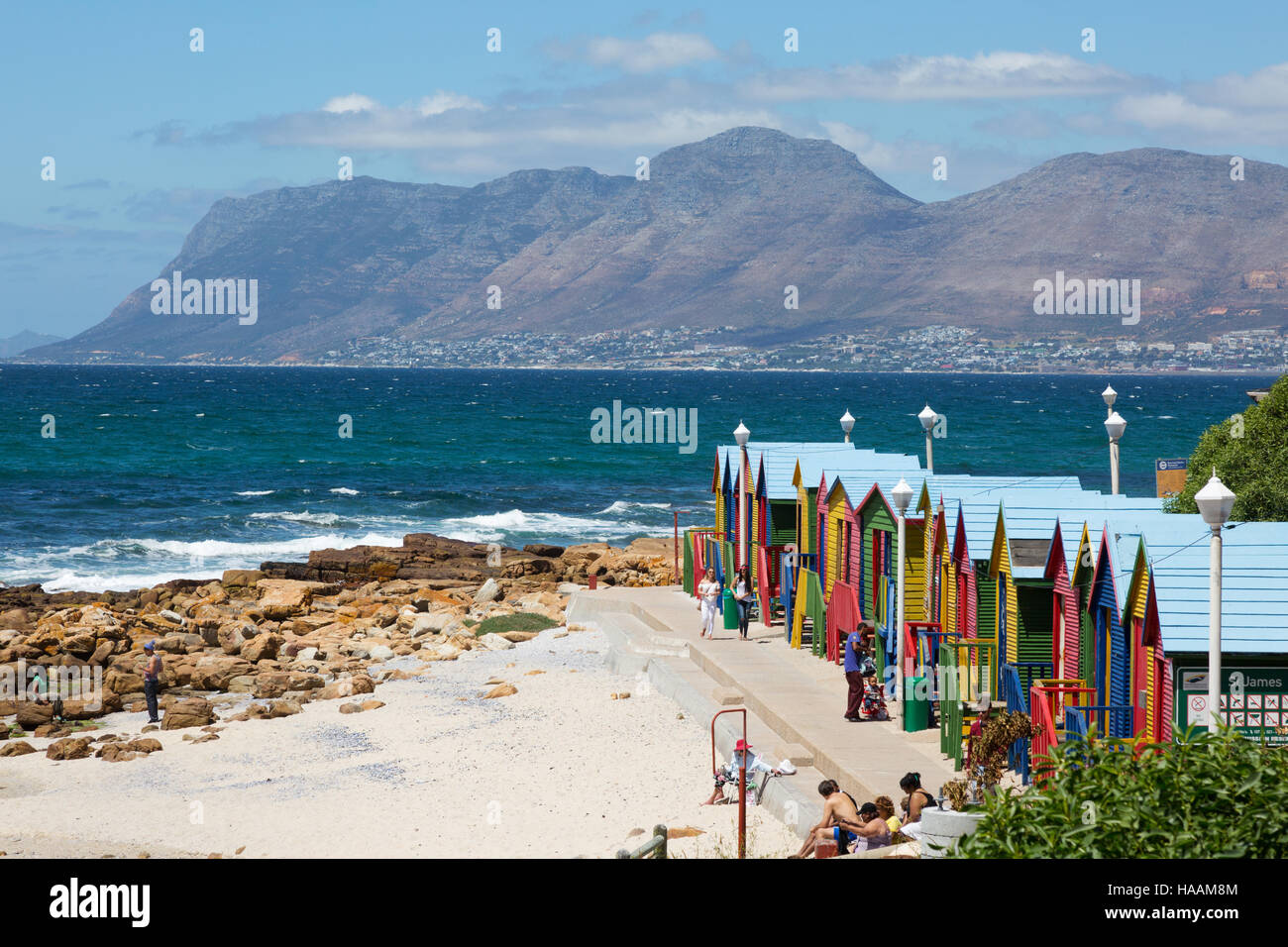 Farbenfrohe Strandhütten und Menschen am Strand von Muizenberg, Western Cape, Südafrika Stockfoto