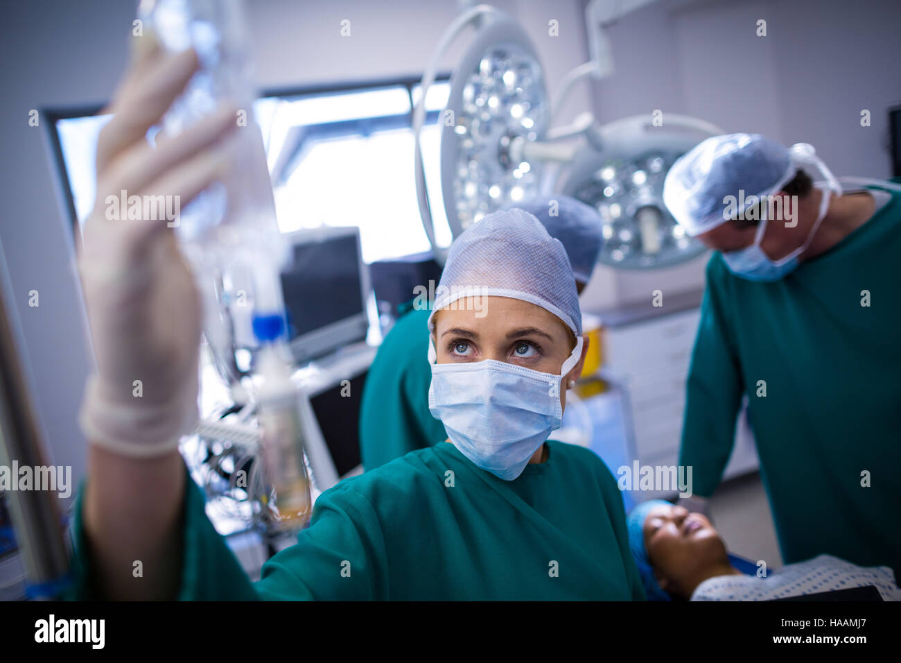 Weiblichen Chirurgen anpassen Tropf in Betrieb-theater Stockfoto