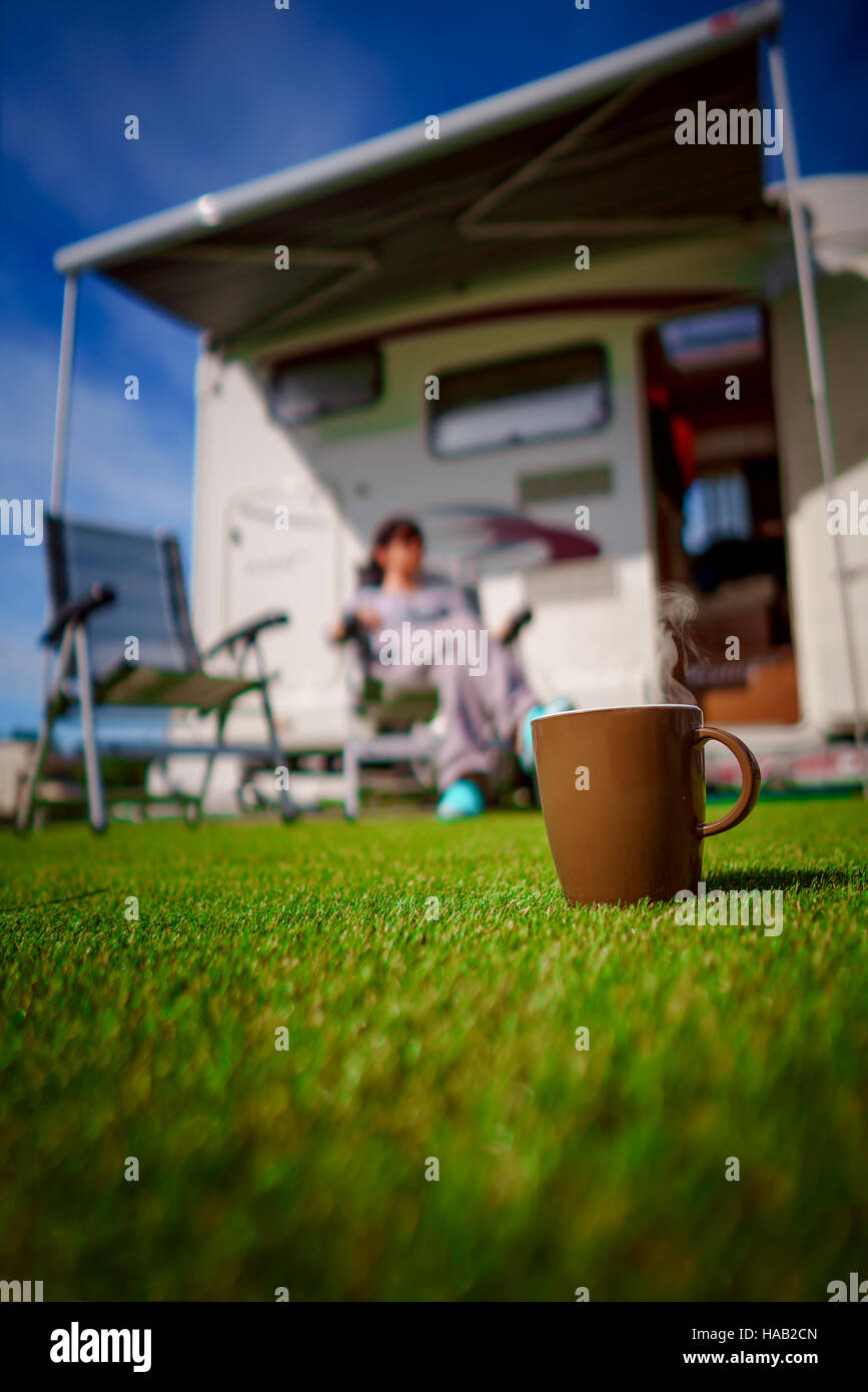 Kaffee-Haferl auf Rasen. Wohnwagen Auto Urlaub. Urlaub mit der Familie reisen, Urlaub im Wohnmobil Stockfoto