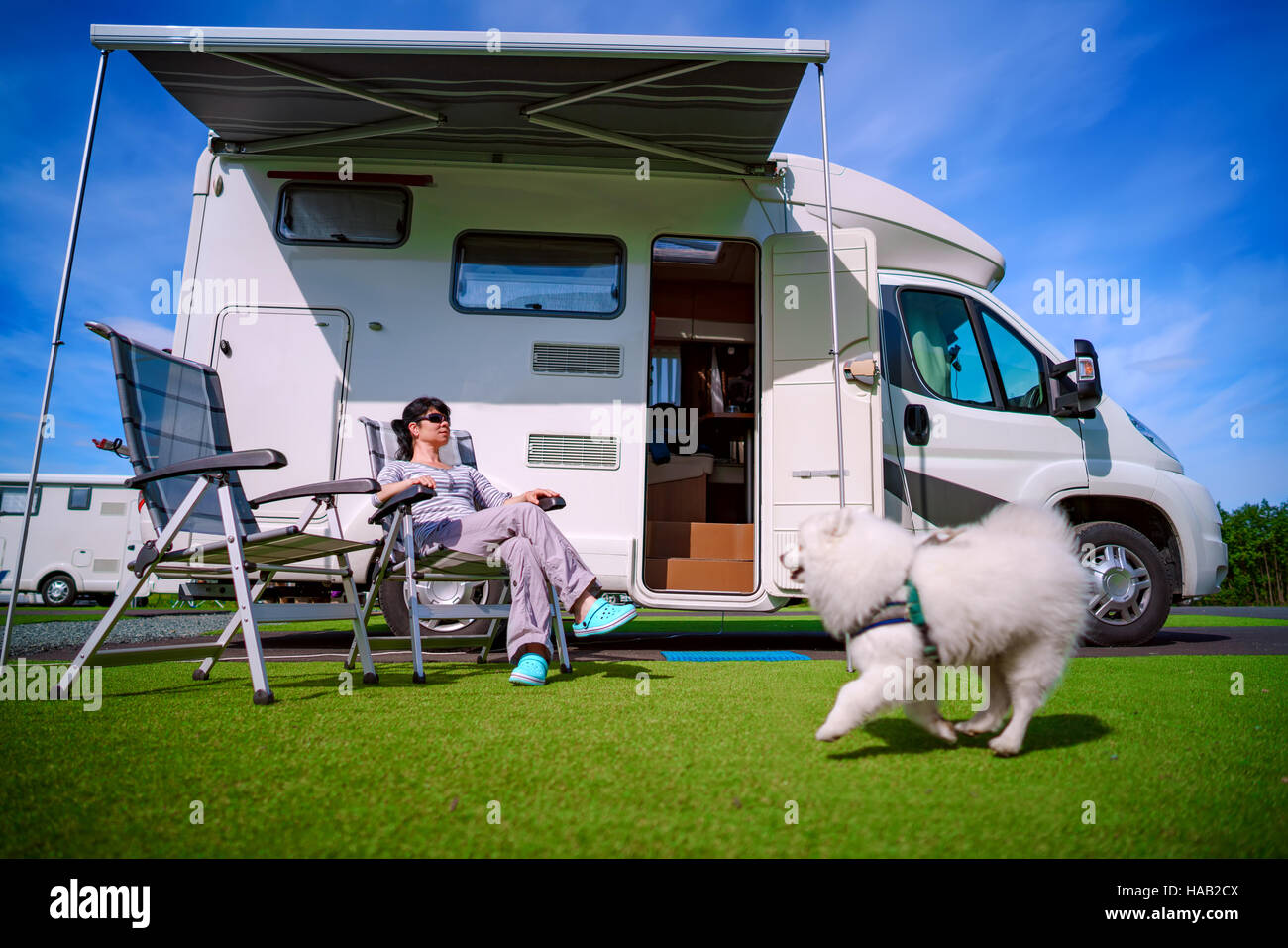 Frau auf einem Stuhl auf die Natur ruht. Wohnwagen Auto Urlaub. Urlaub mit der Familie reisen, Urlaub im Wohnmobil Stockfoto