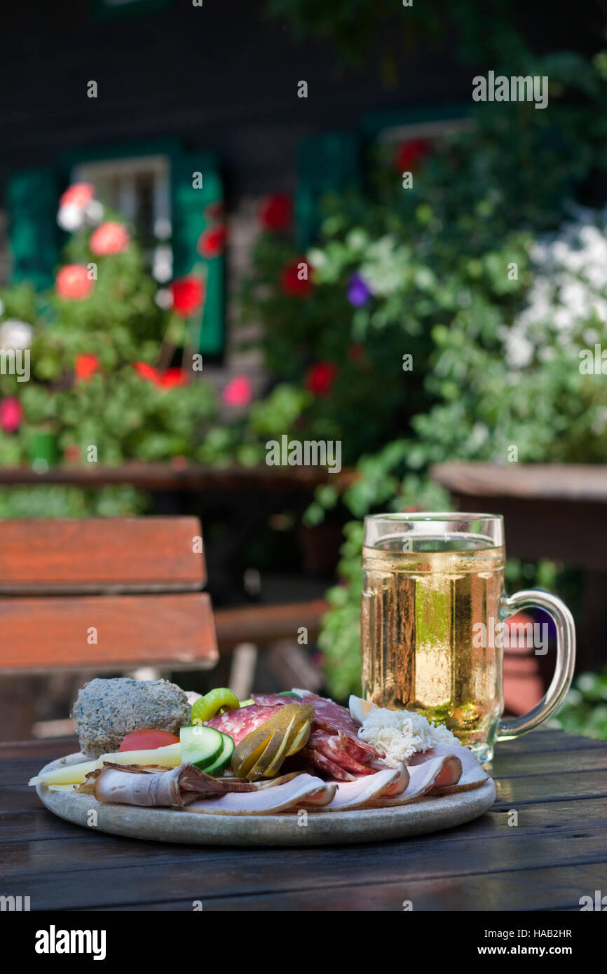 Brettljause - österreichische traditionelle Teller mit Aufschnitt mit Selfmade Inhaltsstoff auf alten Holztisch. Südsteiermark, Europa Stockfoto