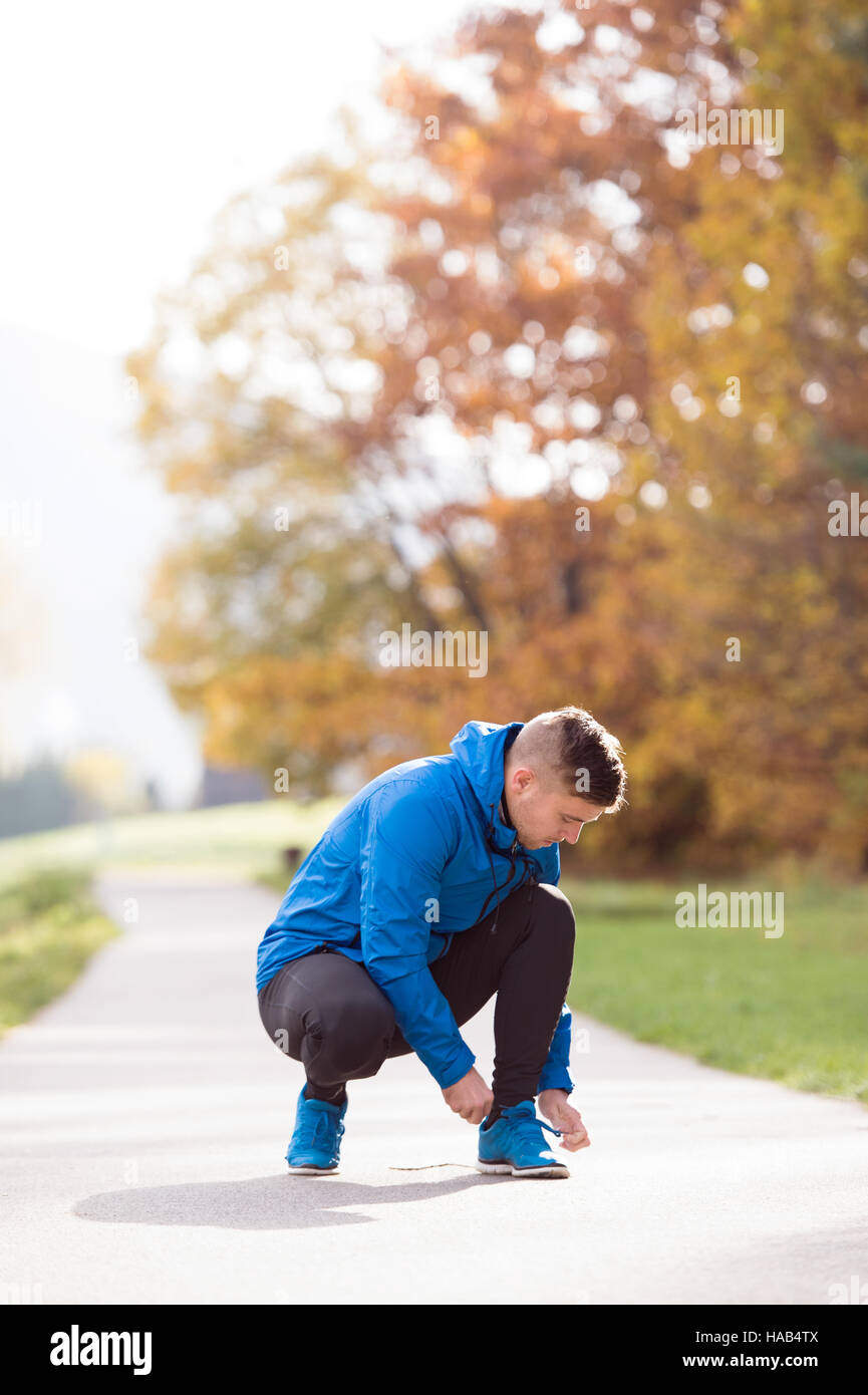Hübscher Junge Läufer hockend, binden von Schnürsenkeln, Nahaufnahme Stockfoto