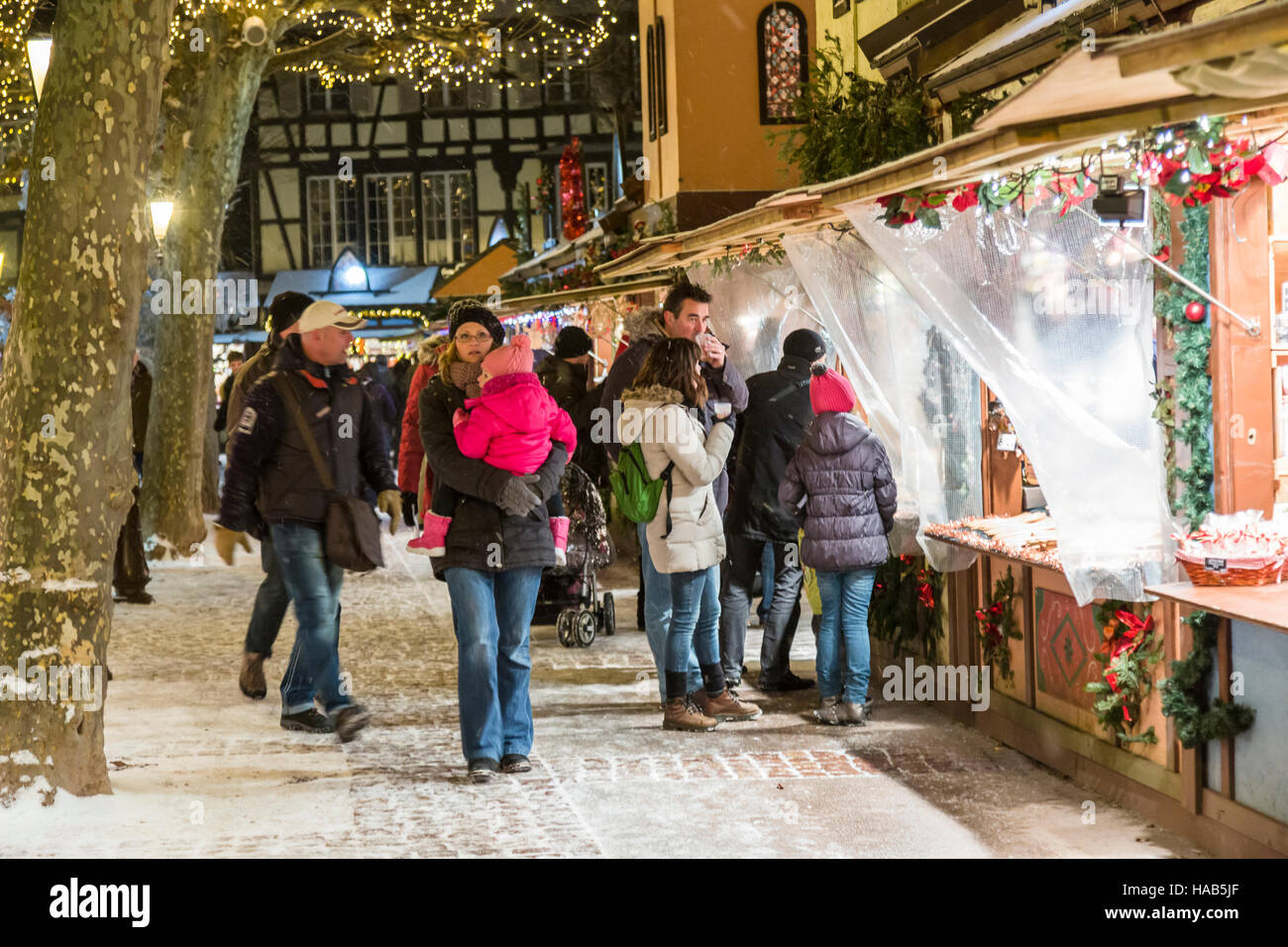Touristen genießen den Weihnachtsmarkt bei Schneefall in Colmar, Wein-Route, Elsass, Haut-Rhin, Frankreich Stockfoto