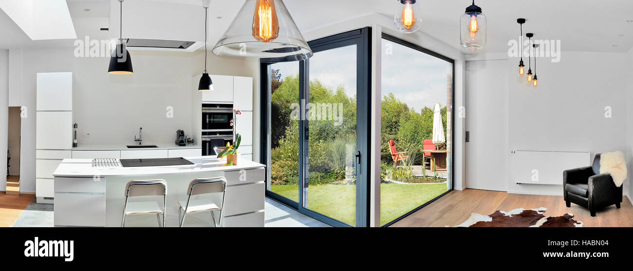 Offene moderne Küche aus Loft mit Blick auf einen üppigen Garten Stockfoto