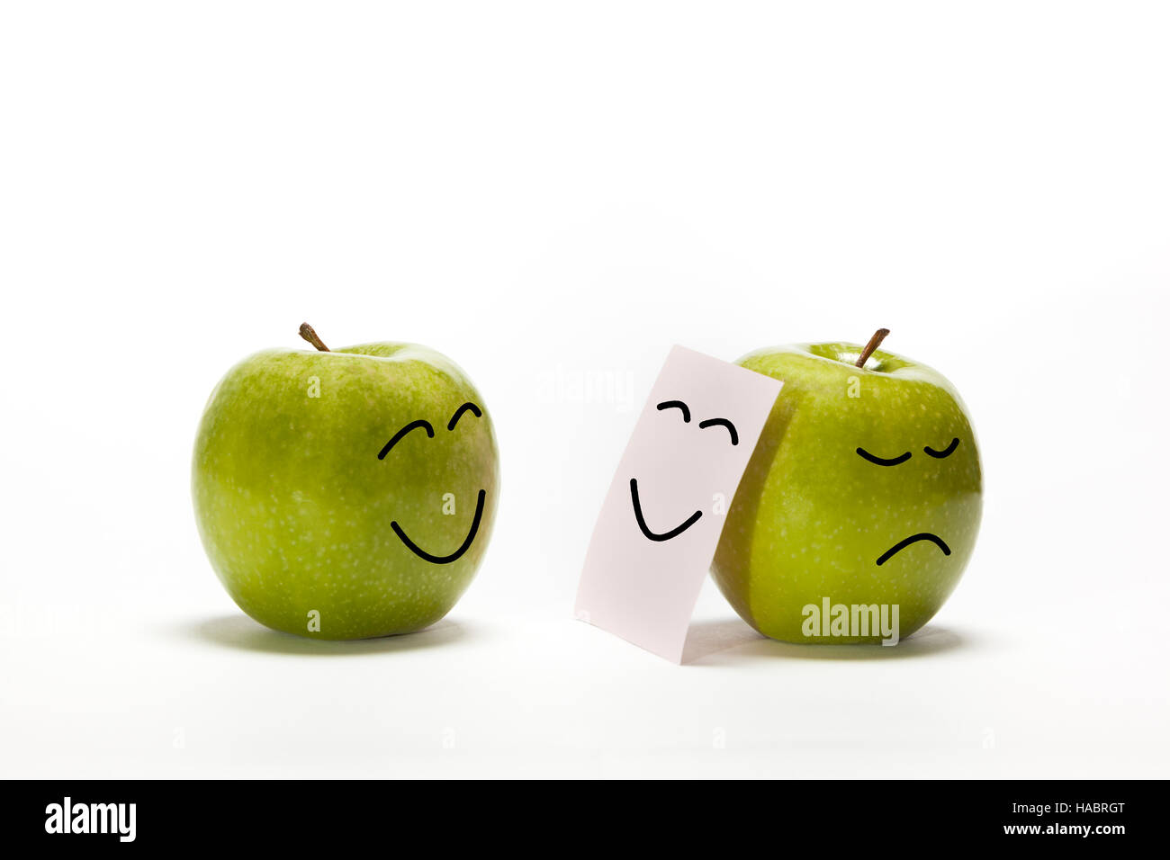 Einen Apfel zu anderen lächelnd, ist, dass seine Traurigkeit hinter einer smily Maske verbergen Stockfoto