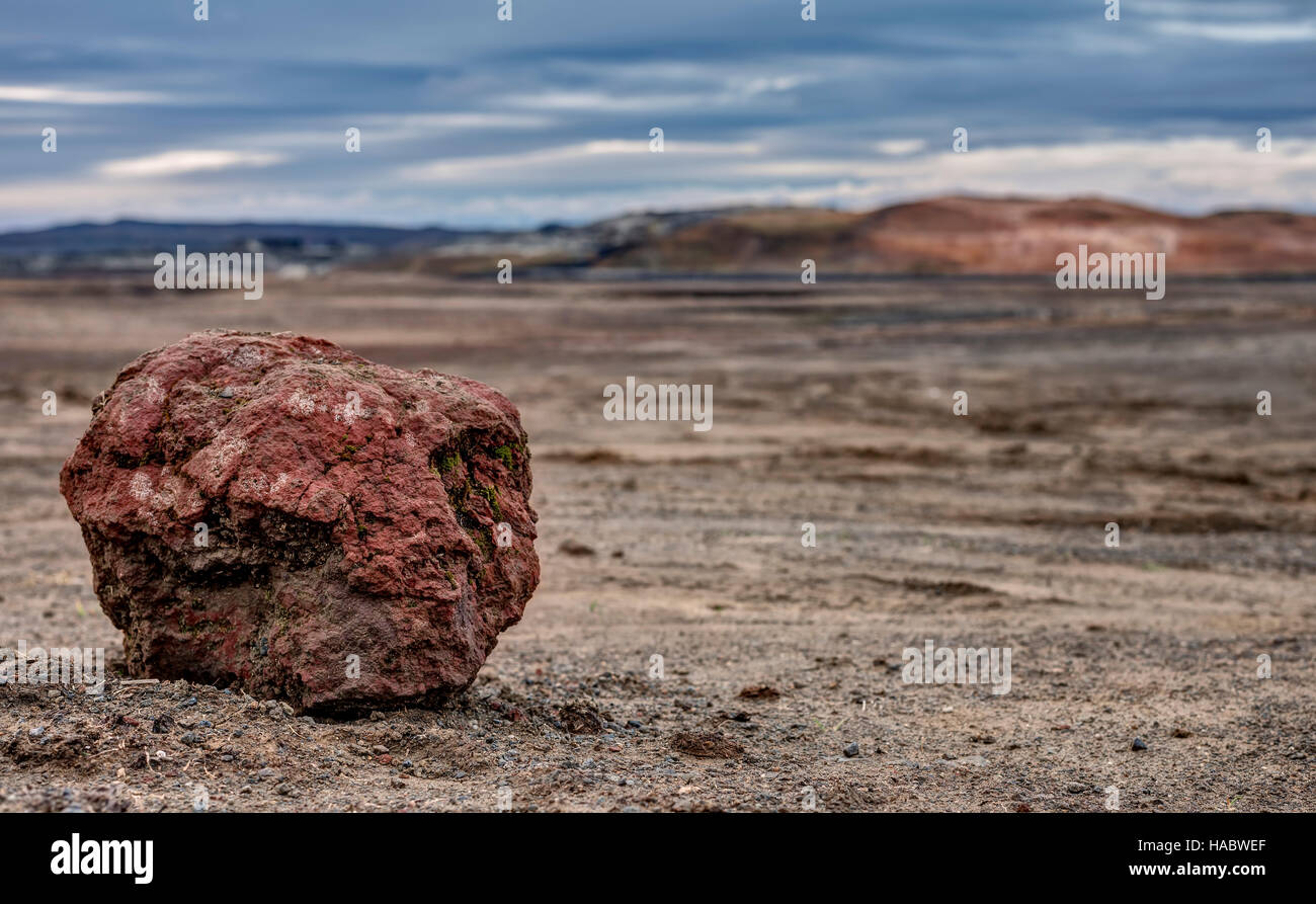 Ein vulkanisches Gestein sitzt isoliert gegen die leere Lavafelder der Krafla-Caldera in Island. Stockfoto