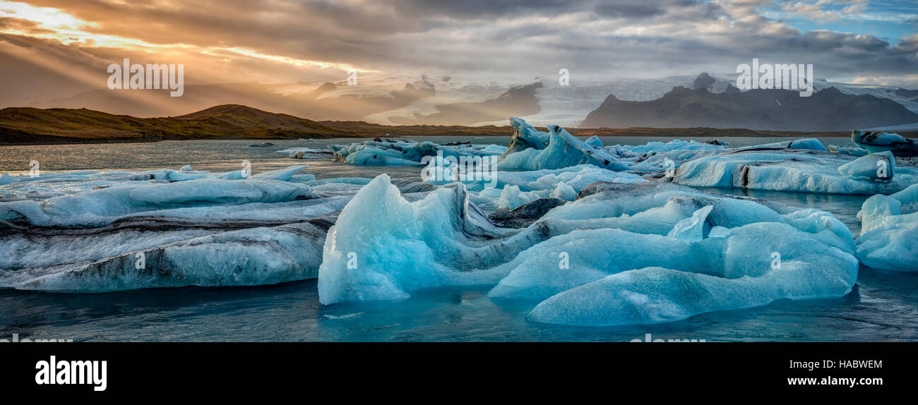 Schlachtfelder des Klimawandels nehmen Form als helle blaue Eisberge brechen bei Sonnenuntergang in Islands Jökulsarlon Glacial Lagune Stockfoto