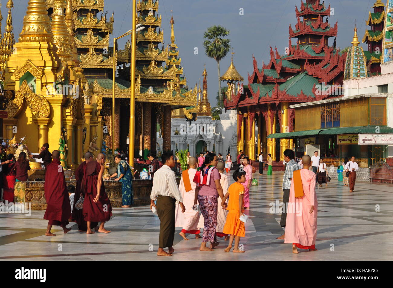 Mönche, Nonnen und Touristen zu Fuß in der Shwedagon-Pagode, Yangon, Myanmar Stockfoto