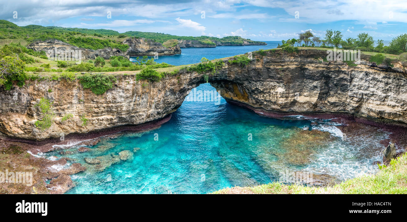 Felsen-Küste. Stein Bogen über dem Meer. Gebrochene Strand, Nusa Penida, Indonesien. Stockfoto