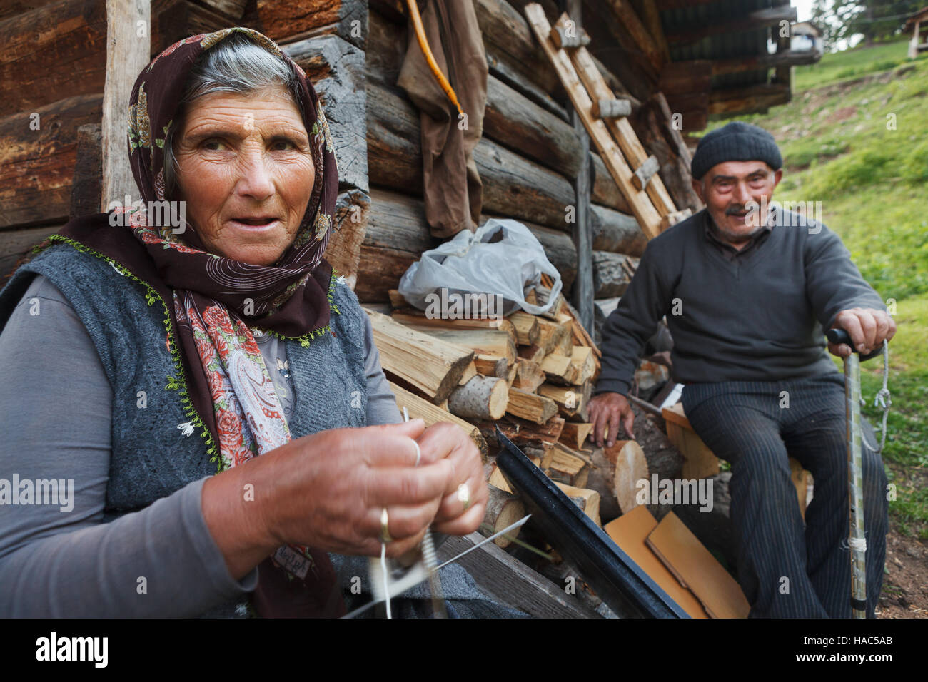 LD-paar in Savsat Provinz Artvin, Türkei. Alte Frau stricken die herkömmliche Wolle Socken für den Winter vor ihrem Holzhaus. Stockfoto
