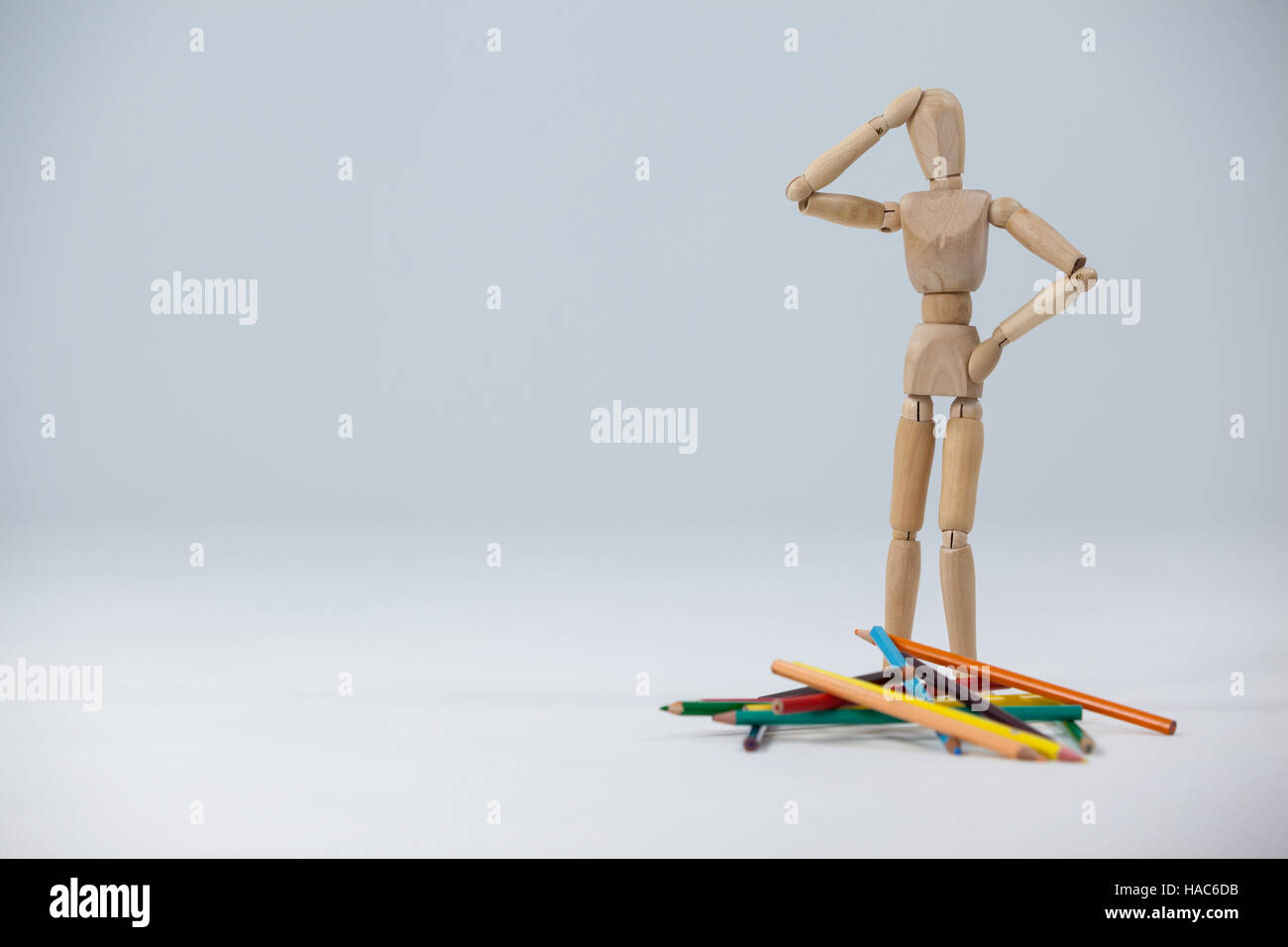 Holz Figur Stand in der Nähe einen Haufen von Farbstiften verwechselt Stockfoto