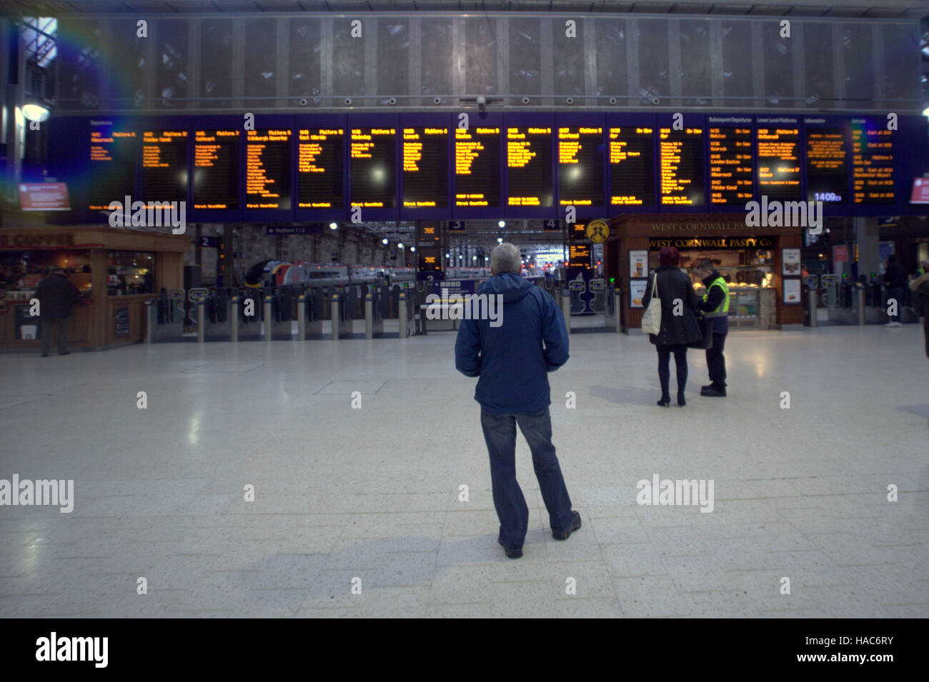 Familie in Glasgow Hauptbahnhof Bahnhof telefonieren suchen Ankünfte board Stockfoto