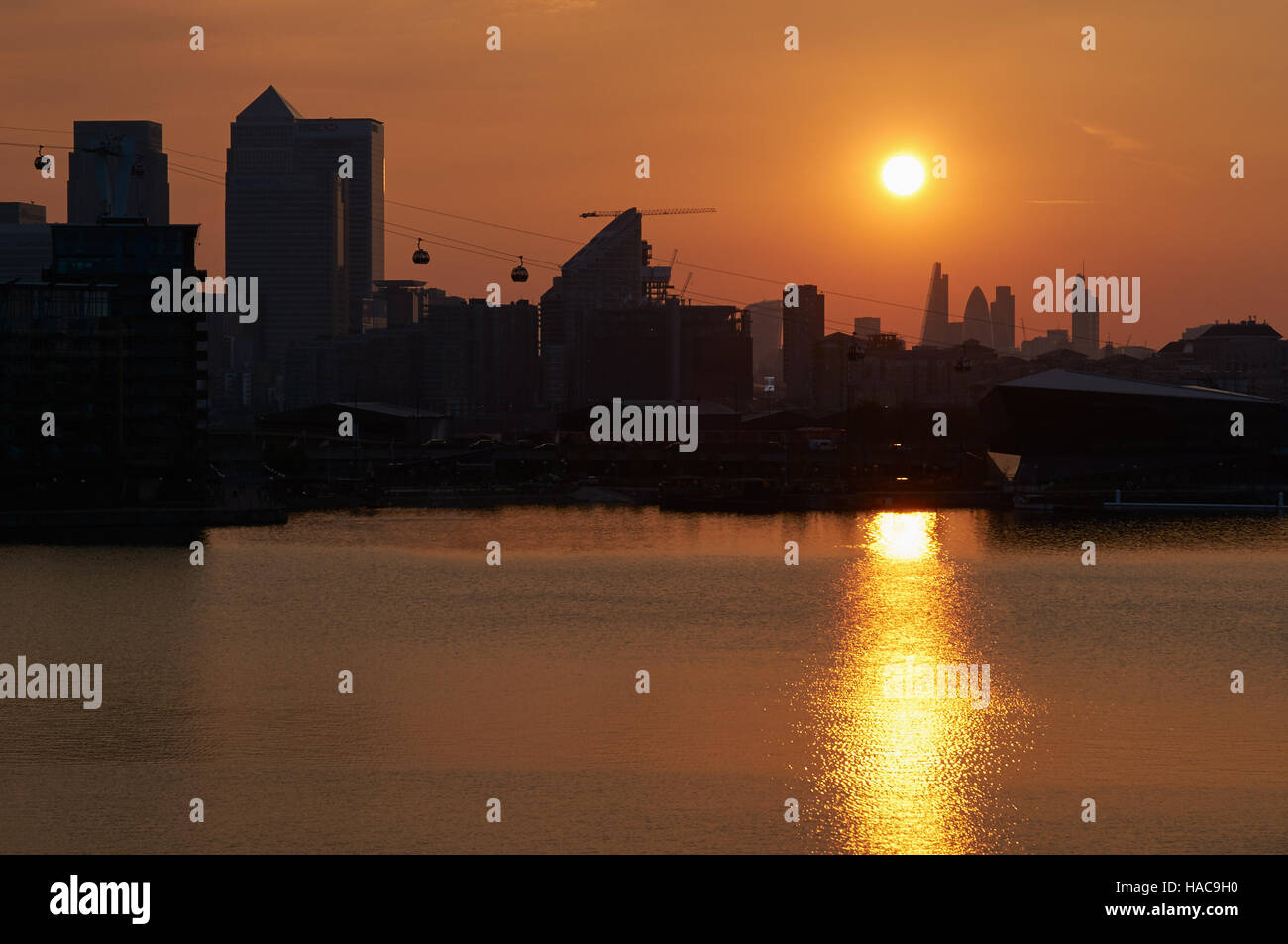 Canary Wharf-Gebäude bei Sonnenuntergang, vom Royal Victoria Dock, London UK Stockfoto