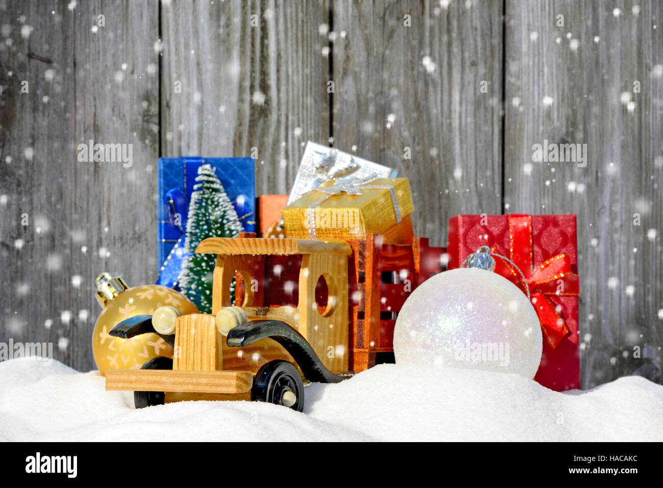 Spielzeug-LKW mit Geschenken, Neujahr Tanne und Kugeln im Schnee Stockfoto