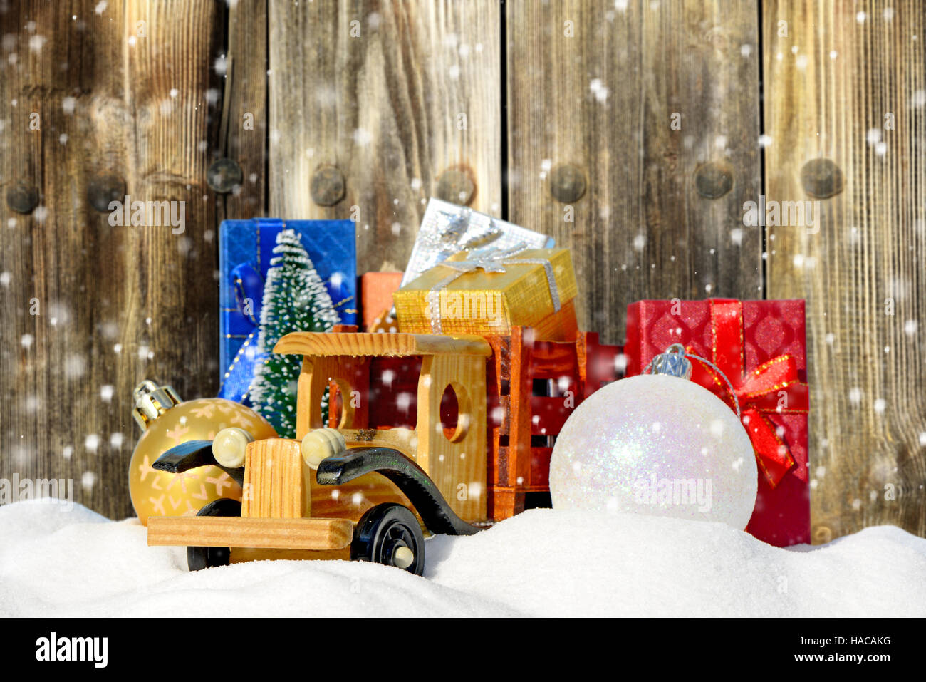 Spielzeug-LKW mit Geschenken, Neujahr Tanne und Kugeln im Schnee Stockfoto
