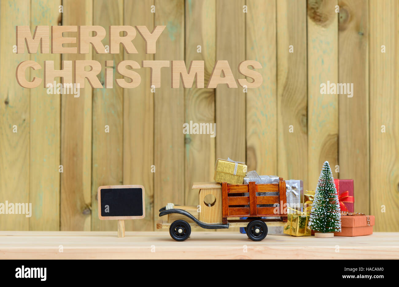 Spielzeug-LKW trägt Geschenke und einen Weihnachtsbaum. Weihnachten Hintergrund Stockfoto