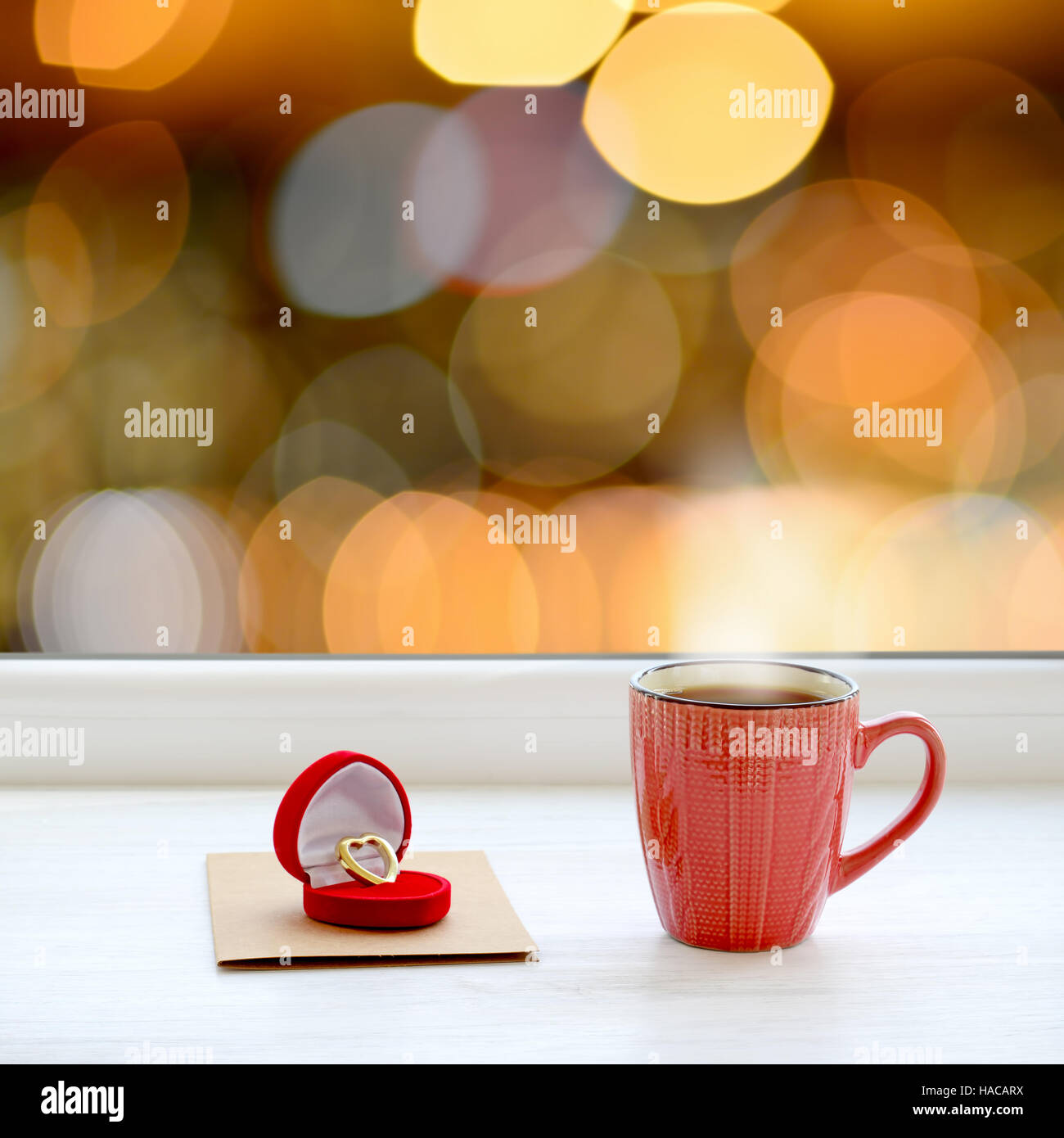 Tasse heißen Tee auf der Fensterbank. Im Hintergrund die hellen Lichter der Stadt als Weihnachten Hintergrund Stockfoto